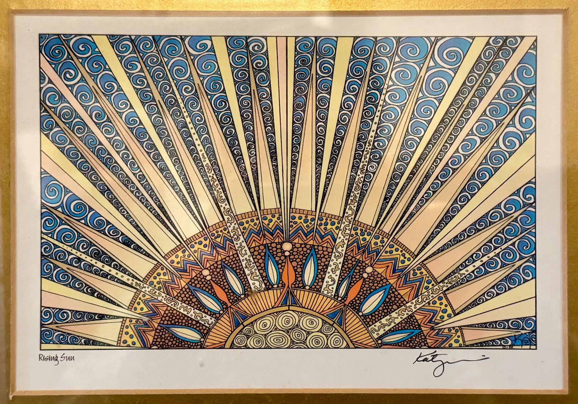 detailed pen and ink illustration of a sun rising in golds, blues and oranges outlined in black ink. rays extend from a central half-circle full of intricate patterns of circles, triangles, spirals, leaf-shapes and zig-zags. 